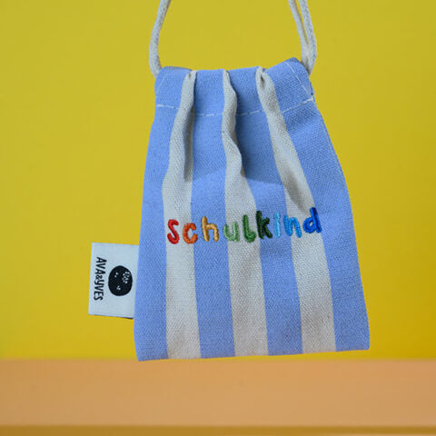 Gewebtes Armband mit handbestickten Perlen Schulkind, flieder mit Säckchen blau/weiss