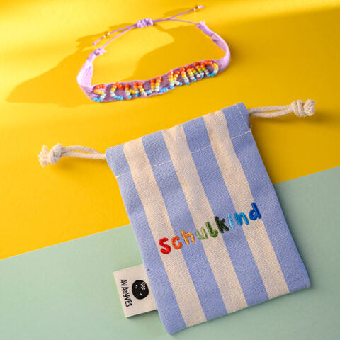 Gewebtes Armband mit handbestickten Perlen Schulkind, flieder mit Säckchen blau/weiss